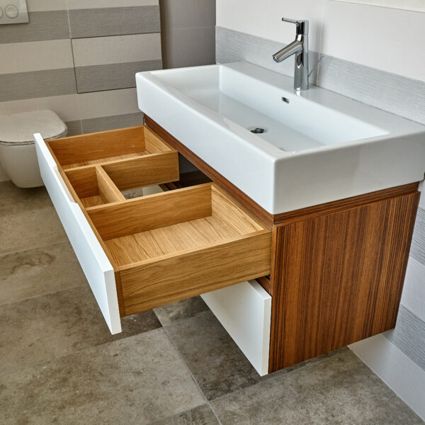 Bathroom console sink vanity in luxury bathroom with teak floor and striped tiles. Stylish interior of modern bathroom. Details furniture